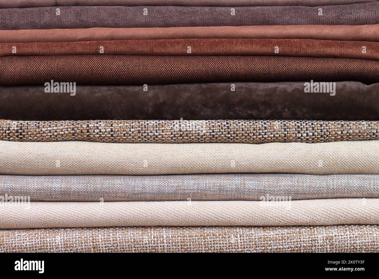 Pile of folded colorful textile. Heap of cloth brown and beige color fabric Stock Photo