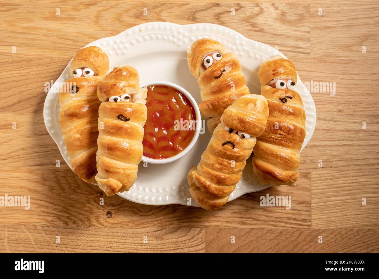 Mummy sausages scary halloween party food decoration wrapped in dough Stock Photo