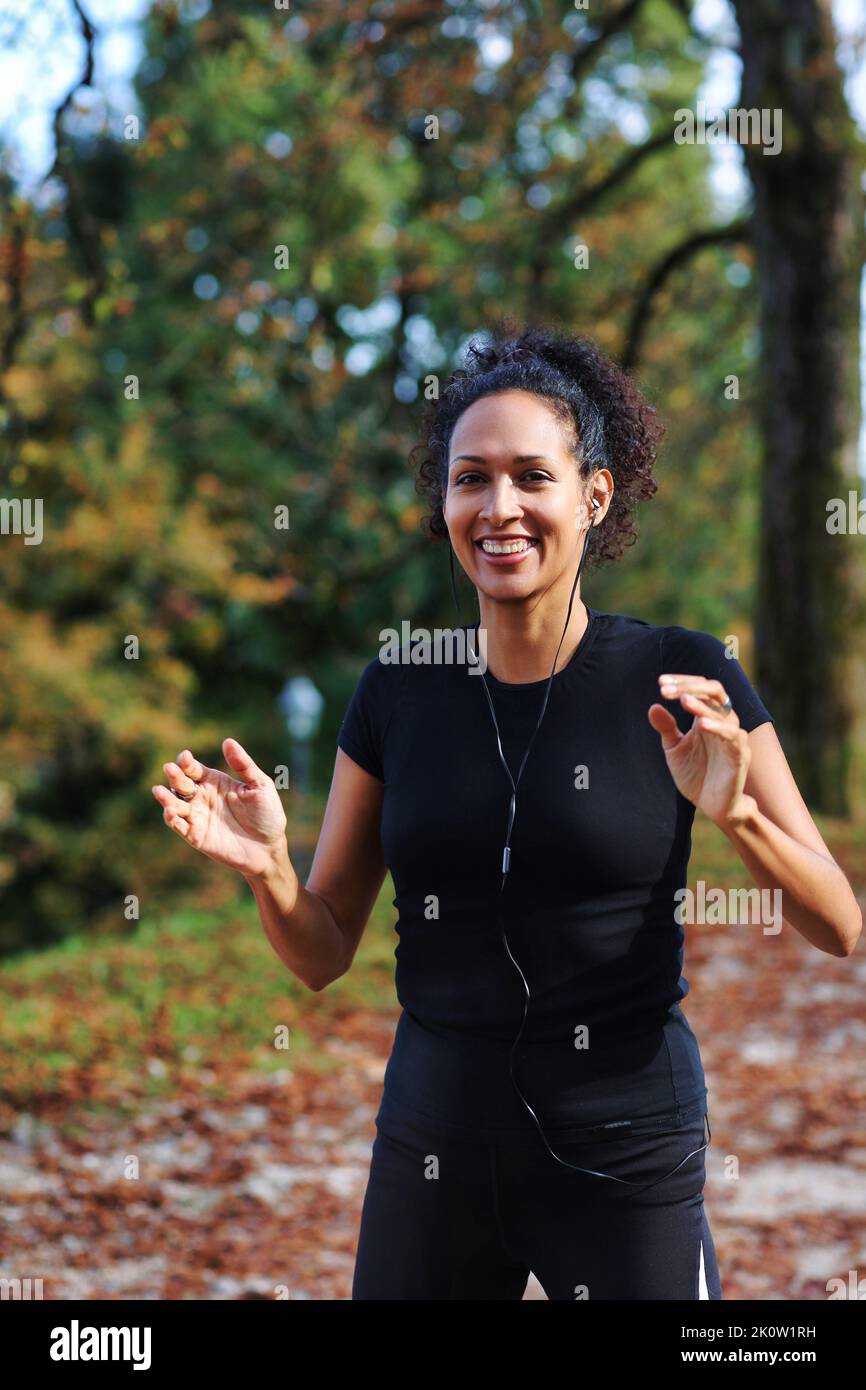 positive middle age woman stretching outdoors preparing for exercise in sportswear Stock Photo
