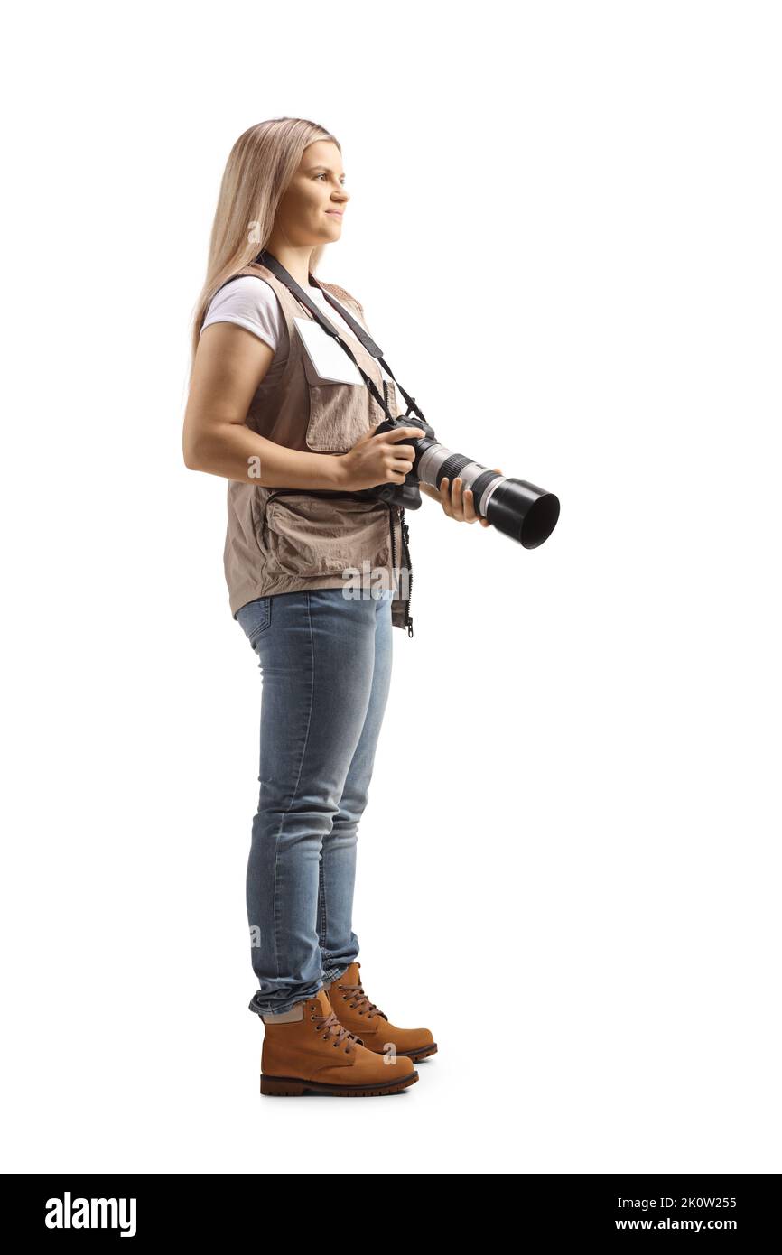 Full length profile shot of a young female photographer carrying a