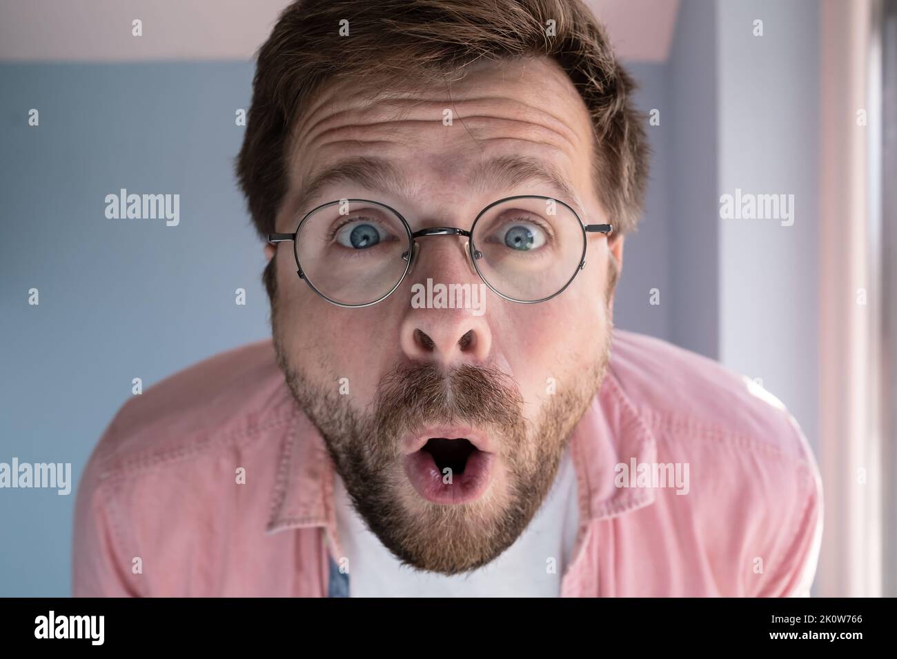 Close-up of an amazed man in glasses, with a funny expression on his face. Stock Photo