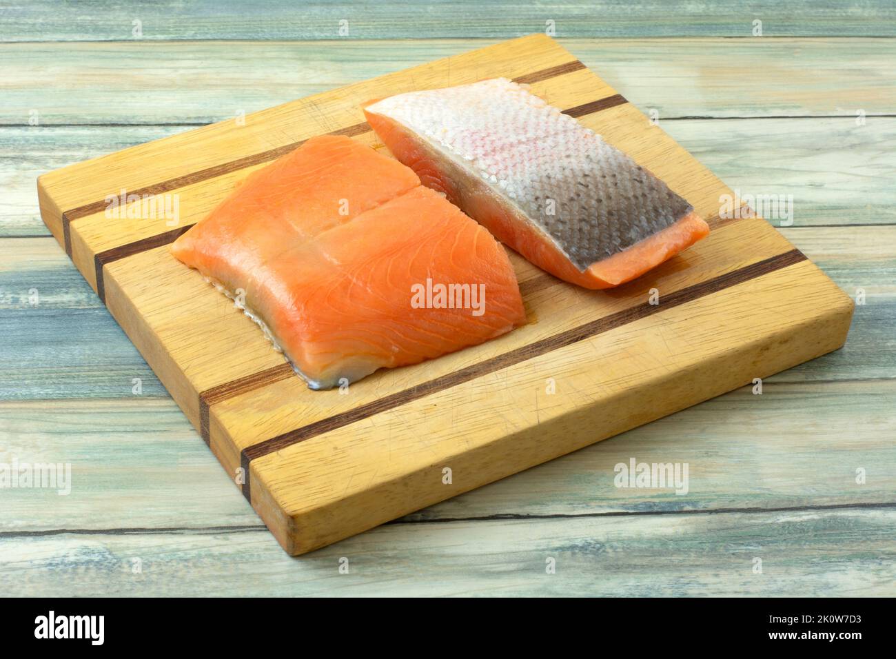 Two fresh raw steelhead trout fillets on wooden cutting board Stock Photo