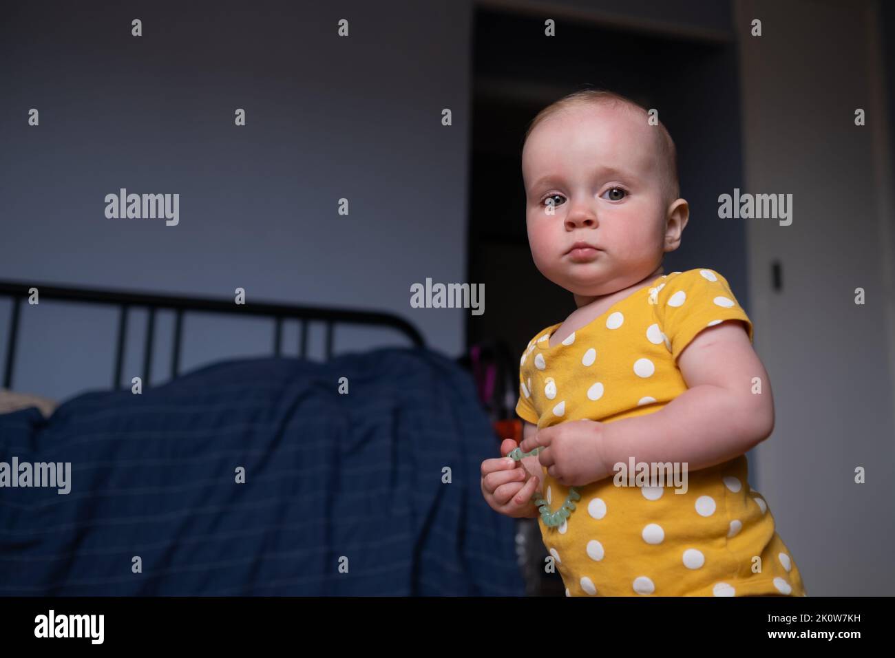 Upset caucasian baby girl looking at camera seriously Stock Photo