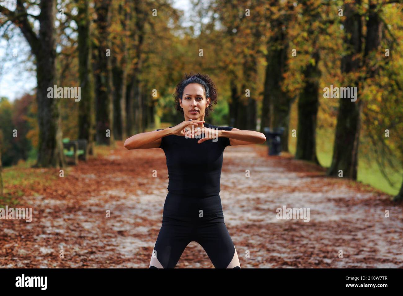 woman outdoors with arms on chest meditating in sportswear Stock Photo