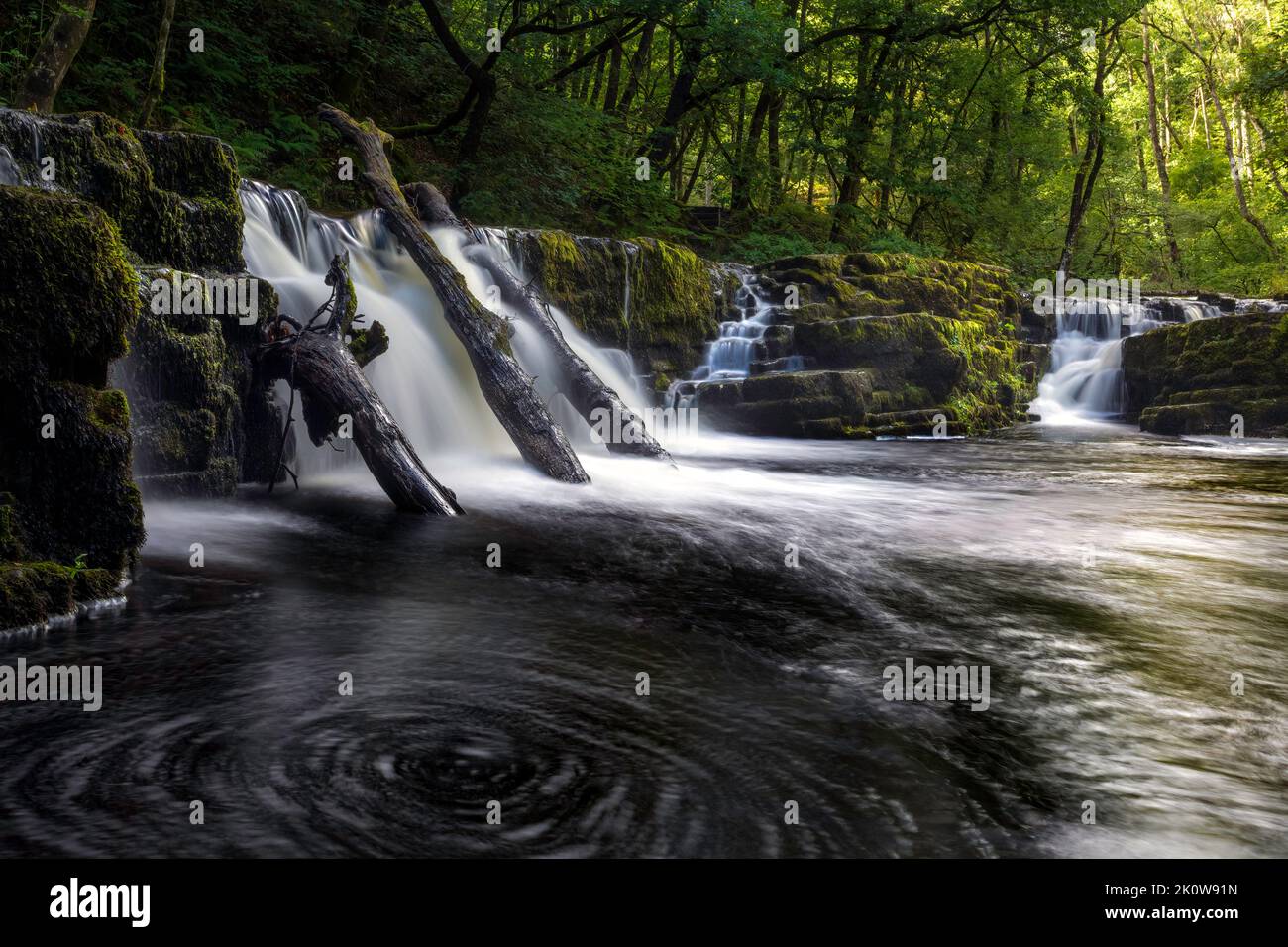 Water spiralling beneath a waterfall on the River Neath in Waterfall Country in South Wales UK Stock Photo
