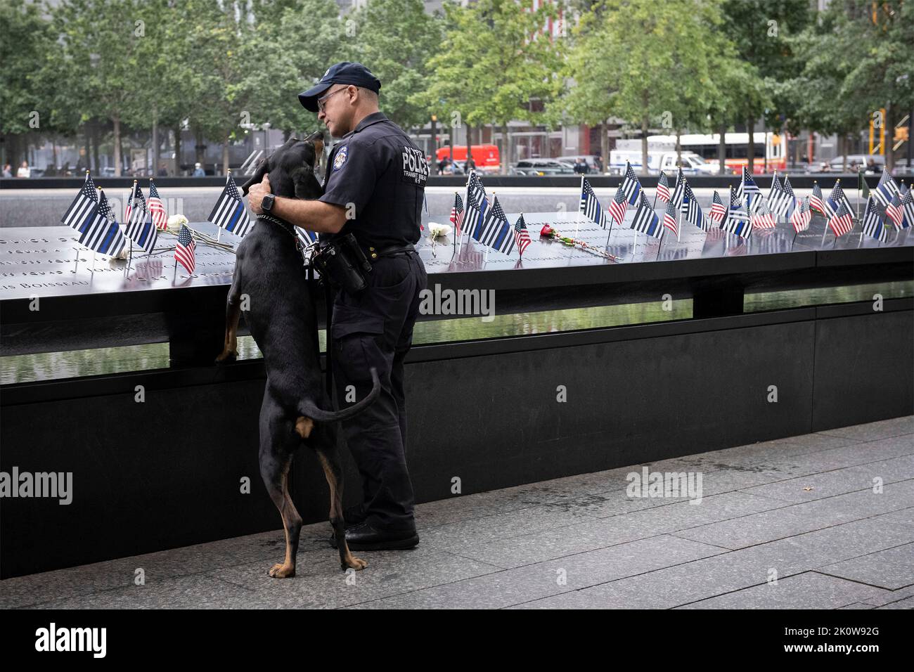 New York, United States of America. 11 September, 2022. A New York City police officer and police dog stop at the names of fellow officers, during the ceremony remembering the victims of the 9/11 attacks at the National September 11 Memorial Museum, September 11, 2022 in New York City. The nation marked the 21st anniversary of the al-Qaida terrorists attacks that killed nearly 3,000 people.  Credit: Sydney Phoenix/DHS Photo/Alamy Live News Stock Photo
