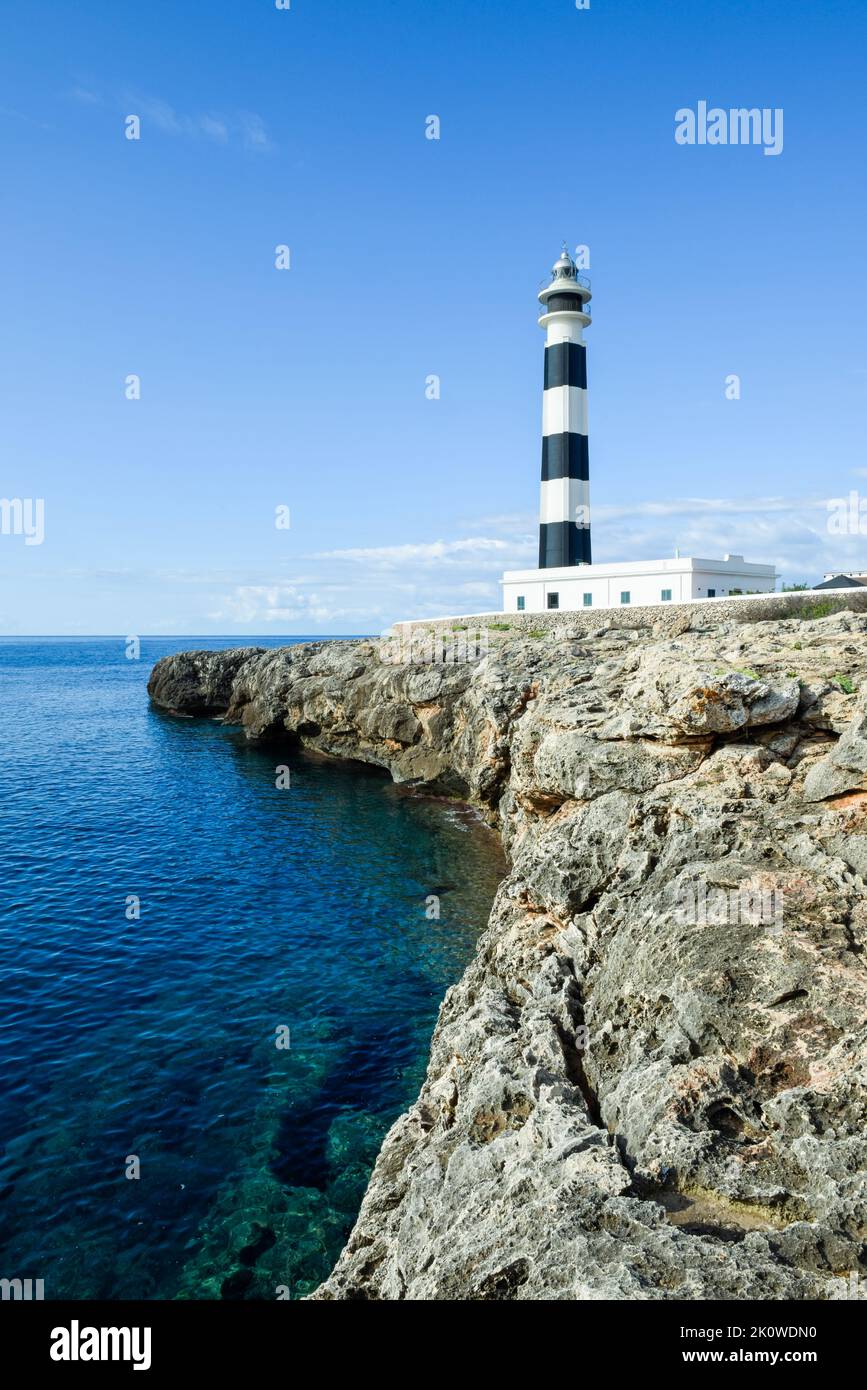 Beautiful clear ocean water with striking coastal feature of a lighthouse on the cliff Stock Photo