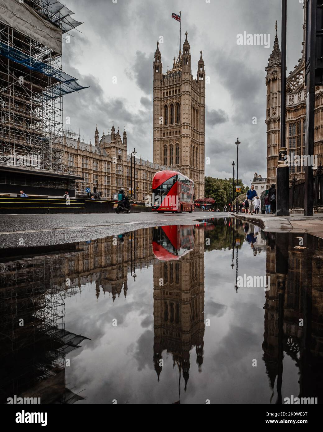 A reflection of a red double decker bus travelling through Westminster after a downpour in London. Stock Photo