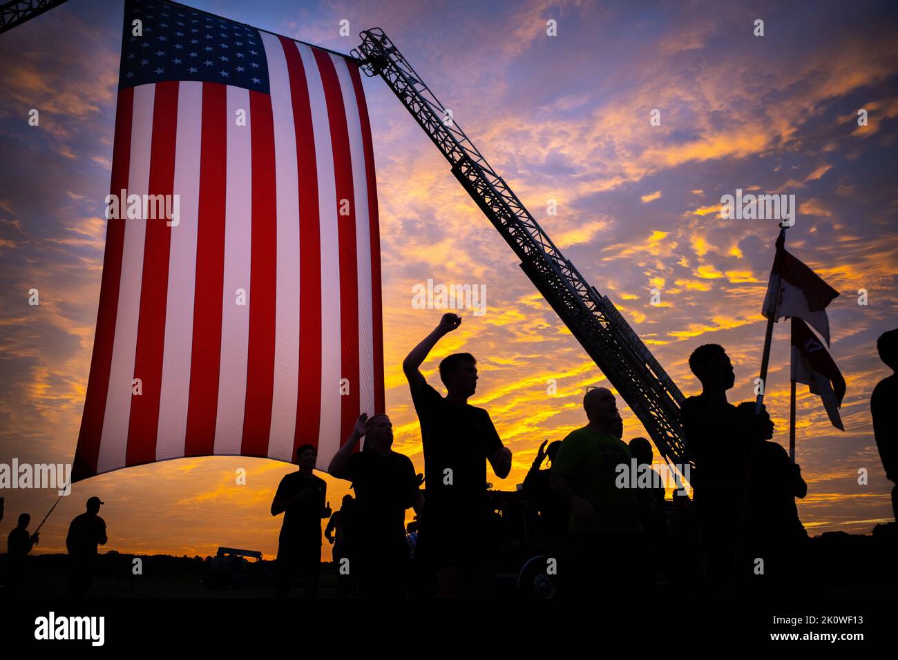Fort Stewart, United States of America. 08 September, 2022. U.S. Army soldiers silhouetted by the sunrise, cross the finish line after completing a 5K Patriot Day Run in remembrance of the 911 attacks at Hunter Army Airfield, September 8, 2022 in Fort Stewart, Georgia. The nation will mark the 21st anniversary of the al-Qaida terrorists attacks that killed nearly 3,000 people on September 11th.  Credit: Sgt. Daniel Malta/DOD Photo/Alamy Live News Stock Photo