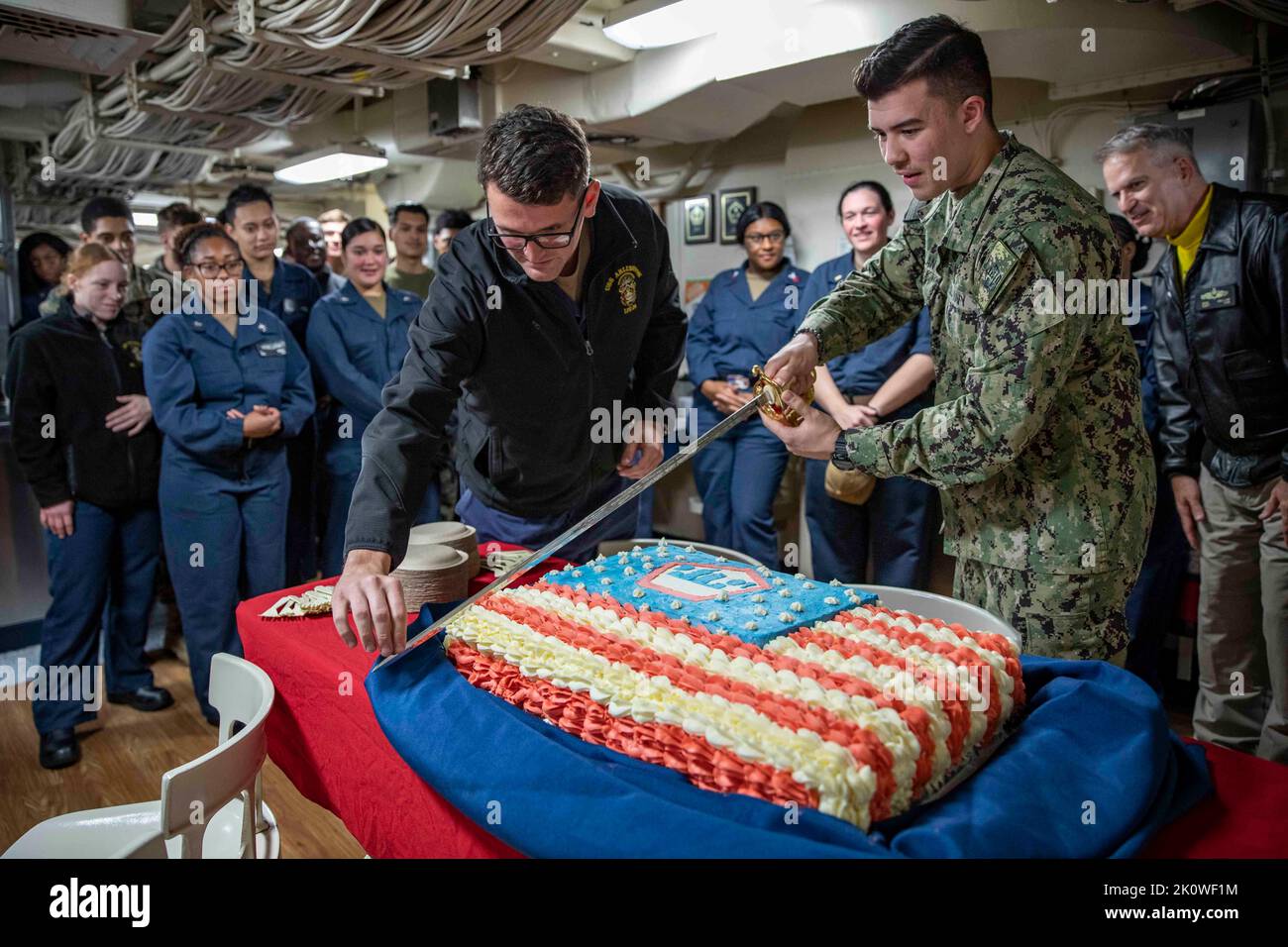 USS Arlington, United States of America. 11 September, 2022. U.S. Navy Lt. Christopher Gardner, left, and Seaman Kai Sablan, cut an American flag cake during a 9/11 ceremony in the mess deck of the San Antonio-class amphibious transport dock ship USS Arlington, September 11, 2022 in the Baltic Sea. The nation marked the 21st anniversary of the al-Qaida terrorists attacks that killed nearly 3,000 people.  Credit: MC1 John Bellino/US Navy Photo/Alamy Live News Stock Photo