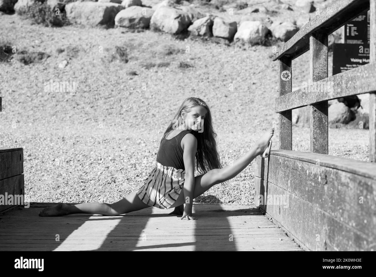 Young ballet dancer posing on a wooden pier by the sea Stock Photo