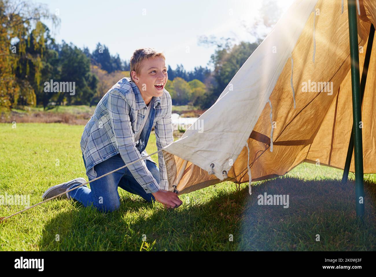 Right, first step pitching the tent. a young boy putting up his tent on