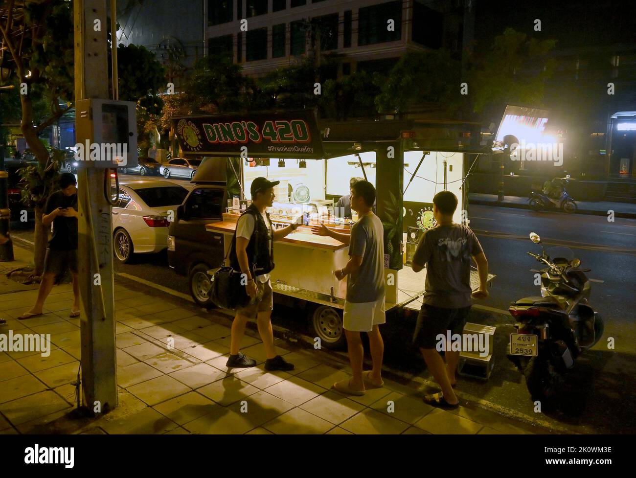 Customers are seen at the 'Dino's 420' pop-up truck. In the popular night life area of Thong Lo in downtown Bangkok, marijuana pop-up trucks sell legal marihuana for personal use. The Kingdom of Thailand is the first nation in Asia to decriminalize marijuana for medical and personal use. On June 9, 2022, marihuana was removed from the category of narcotic drugs making it legal to sell and buy the herb. Stock Photo