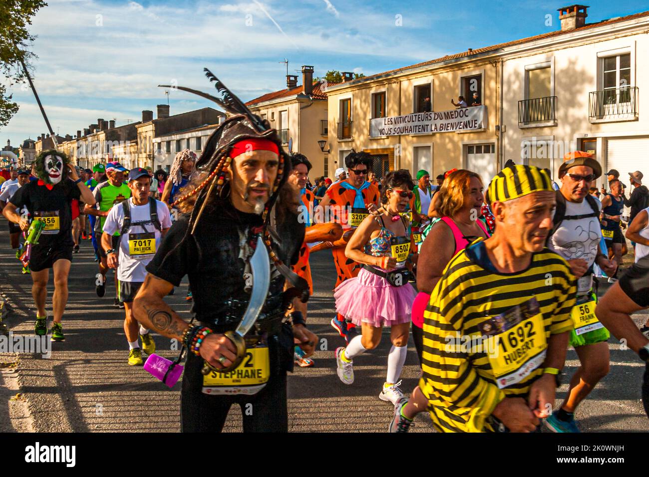 The first meters for the runners of the 36th Marathon des Chateaux du Medoc. Start and finish are in the village of Pauillac. The 2022 motto is 'Film' 'Fait son cinema'. Over 8,0000 participants set off on the traditional 42.195-kilometer route through a total of 25 Medoc wineries Stock Photo