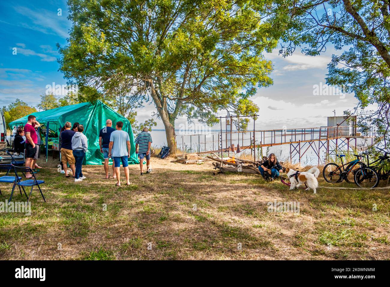 Spectators along the route of the 36th Marathon des Chateaux du Medoc. Whole groups turn the day into a party with friends. Here, on the banks of the Gironde with its typical fishermen's huts, the "carrelets", a barbecue is prepared for over 30 people. One of many private parties on the edge of the marathon. Lesparre-Médoc, France Stock Photo