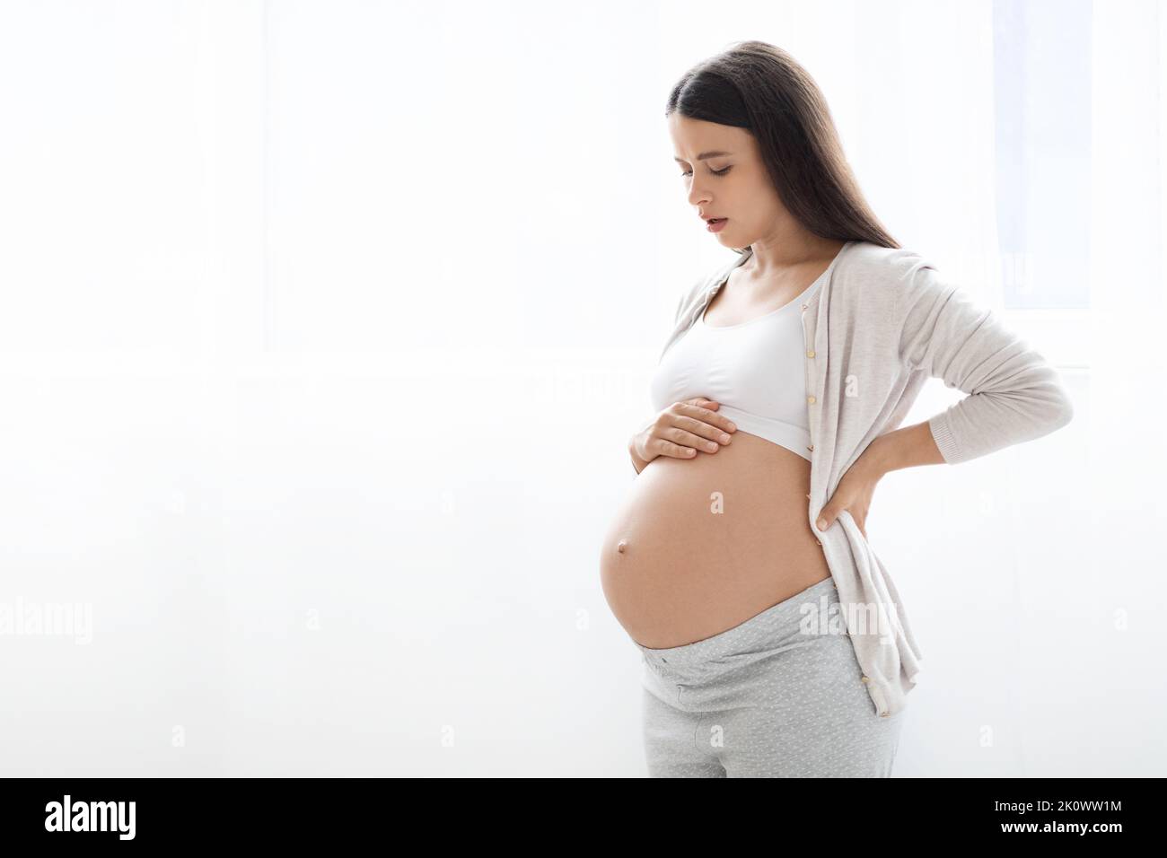 Unhappy pregnant woman having back pain, copy space Stock Photo
