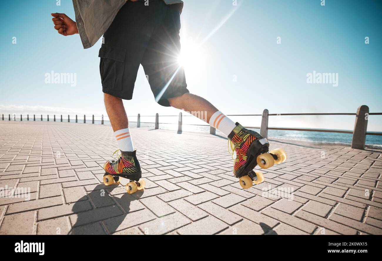 Person roller skating, sport and fitness on a sidewalk, sea or ocean shore. Sun flare, exercise and sports with roller skate cardio workout, training Stock Photo