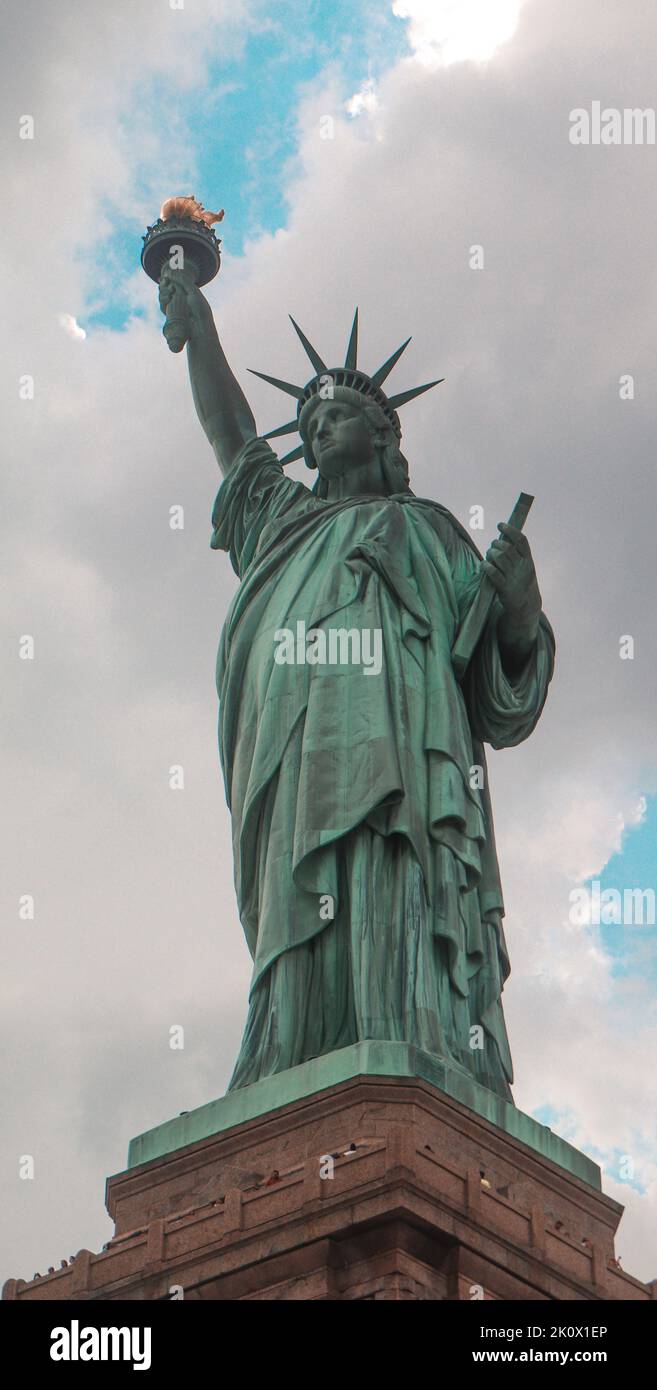 A low angle shot of the Statue of Liberty against a cloudy sky Stock Photo