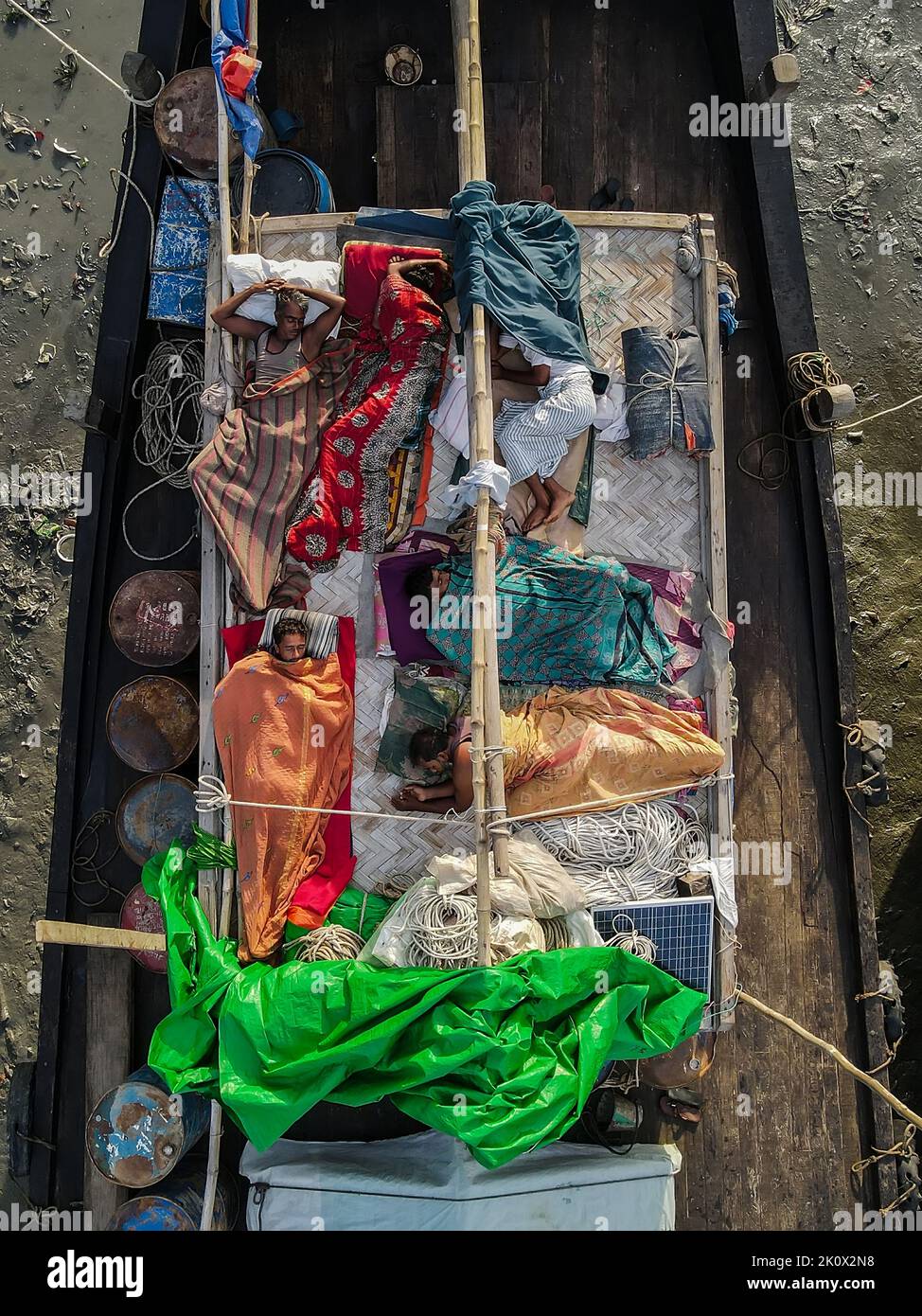 Fishermen sleeping on fishing boats. They catch fish in the deep sea all night and come to the Chittagong fishing ghat on the river bank and sleep under the open sky in the boat. Chittagong and Cox's Bazar is the main center of sea fishing in Bangladesh. More than 40,000 families engaged with sea fishing. Chittagong, Bangladesh. Stock Photo