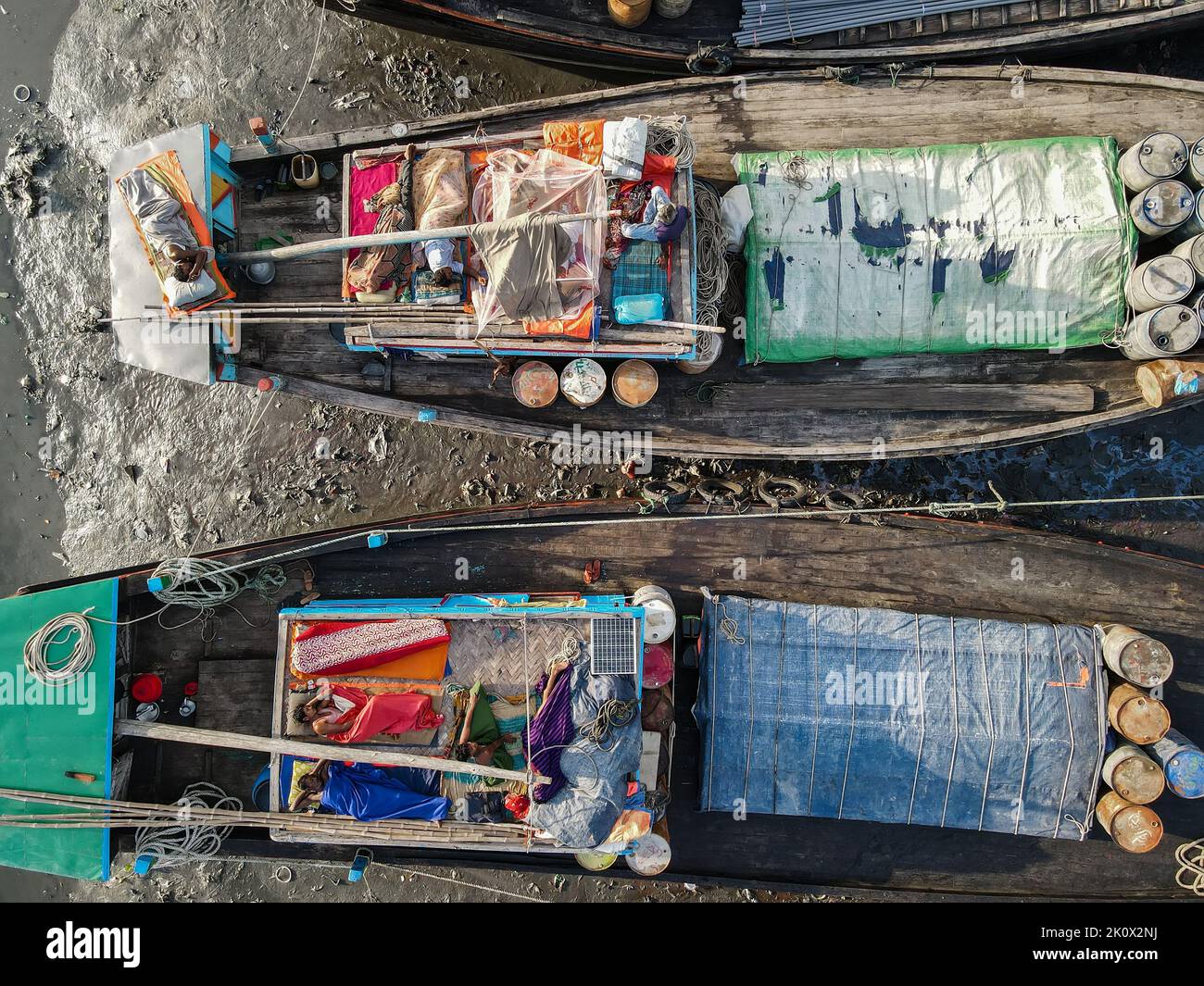 Fishermen sleeping on fishing boats. They catch fish in the deep sea all night and come to the Chittagong fishing ghat on the river bank and sleep under the open sky in the boat. Chittagong and Cox's Bazar is the main center of sea fishing in Bangladesh. More than 40,000 families engaged with sea fishing. Chittagong, Bangladesh. Stock Photo