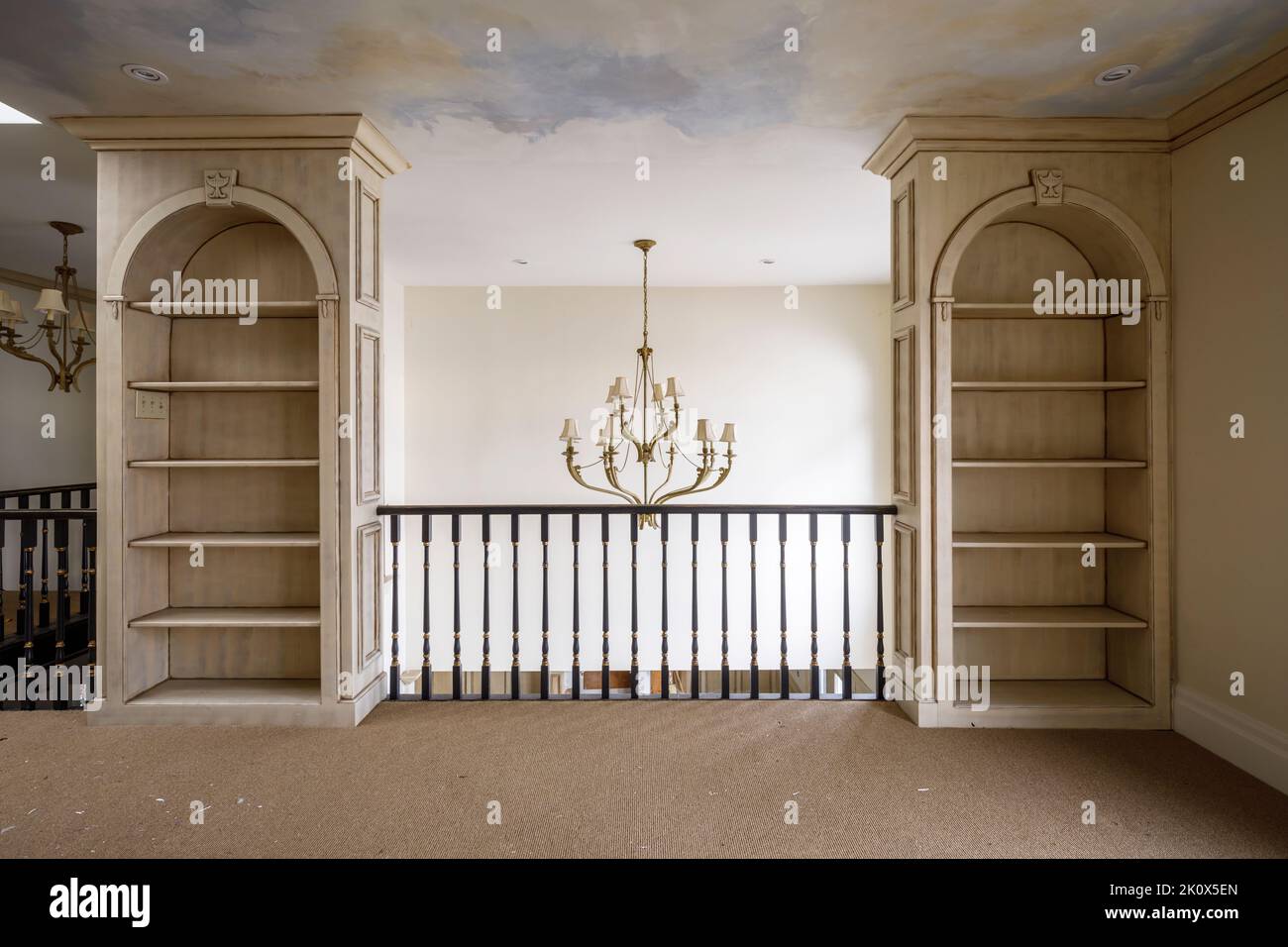Built-in bookcases and a chandelier hanging from a vaulted ceiling. This home has since been demolished. Stock Photo