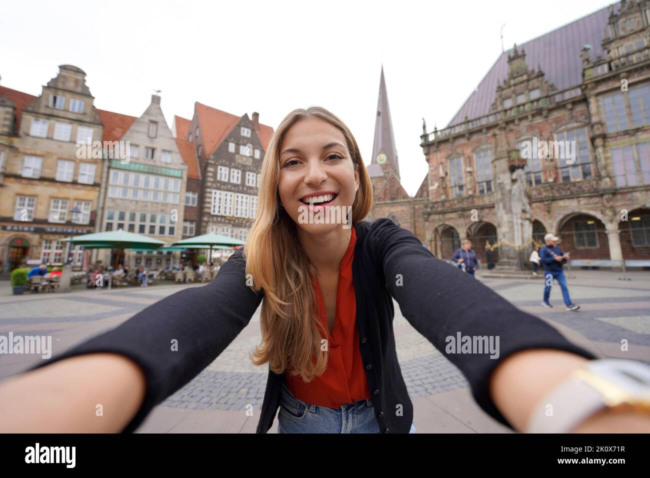 Pretty woman takes selfie photo in Bremen Market Square with Roland statue, Bremen, Germany Stock Photo