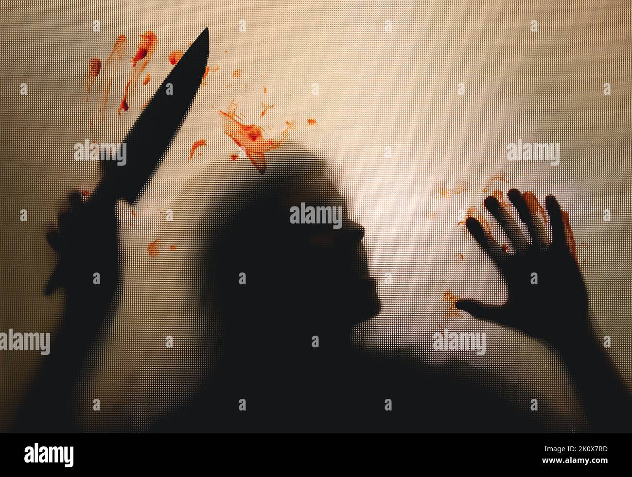 Horror, halloween background - Shadowy figure behind glass holding a knife with blood Stock Photo