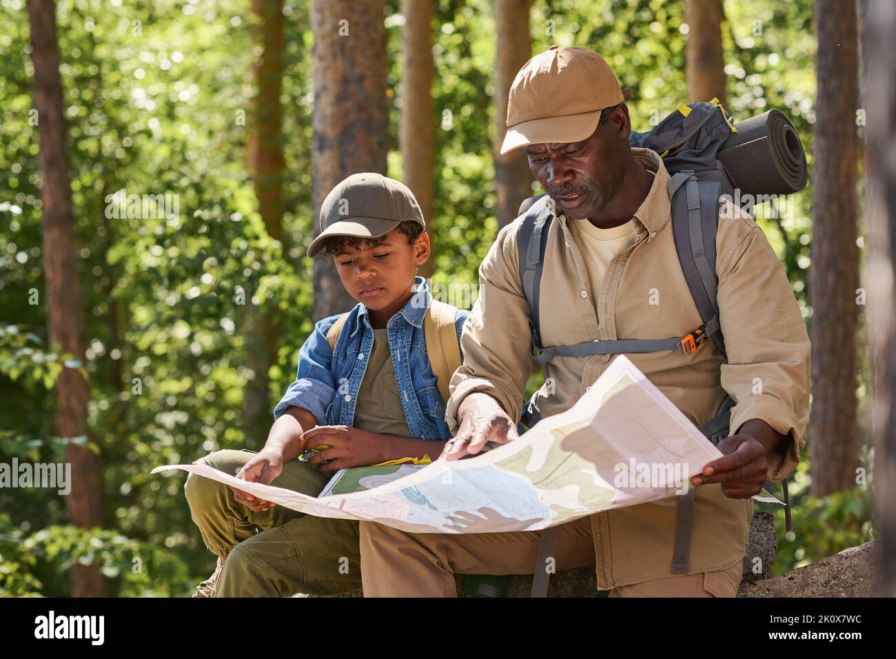 Father and son hiking in forest. Looking at map Stock Photo - Alamy