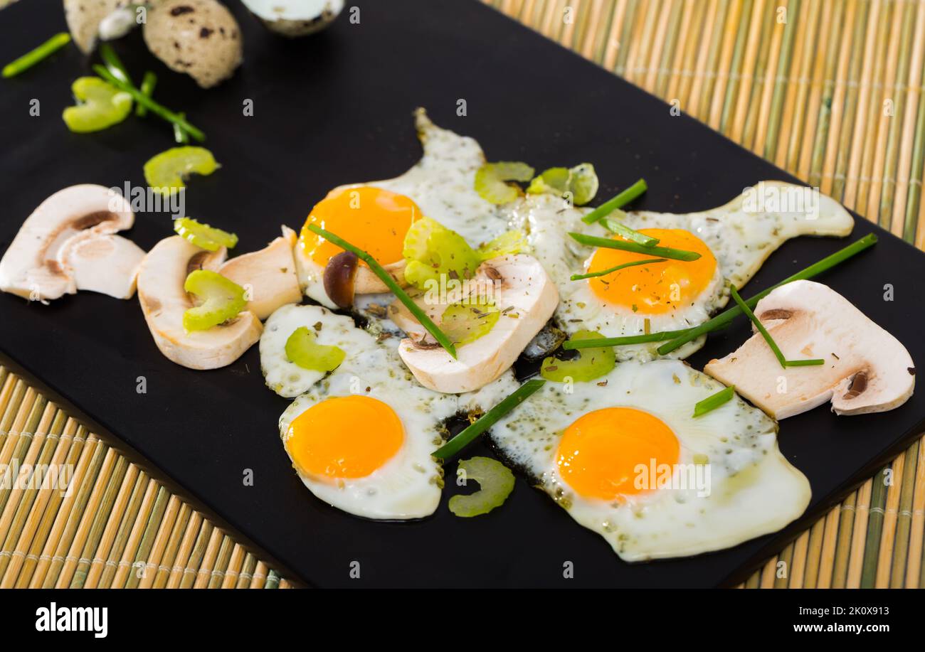 Fried quail eggs with champignons Stock Photo