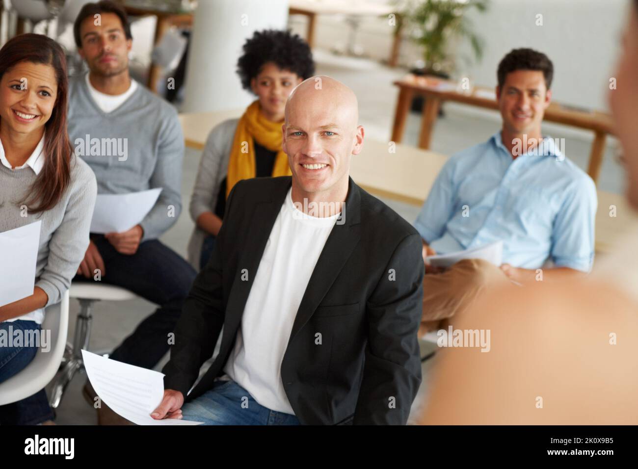 Theyre all on the same page. A group of colleagues sitting in a ...
