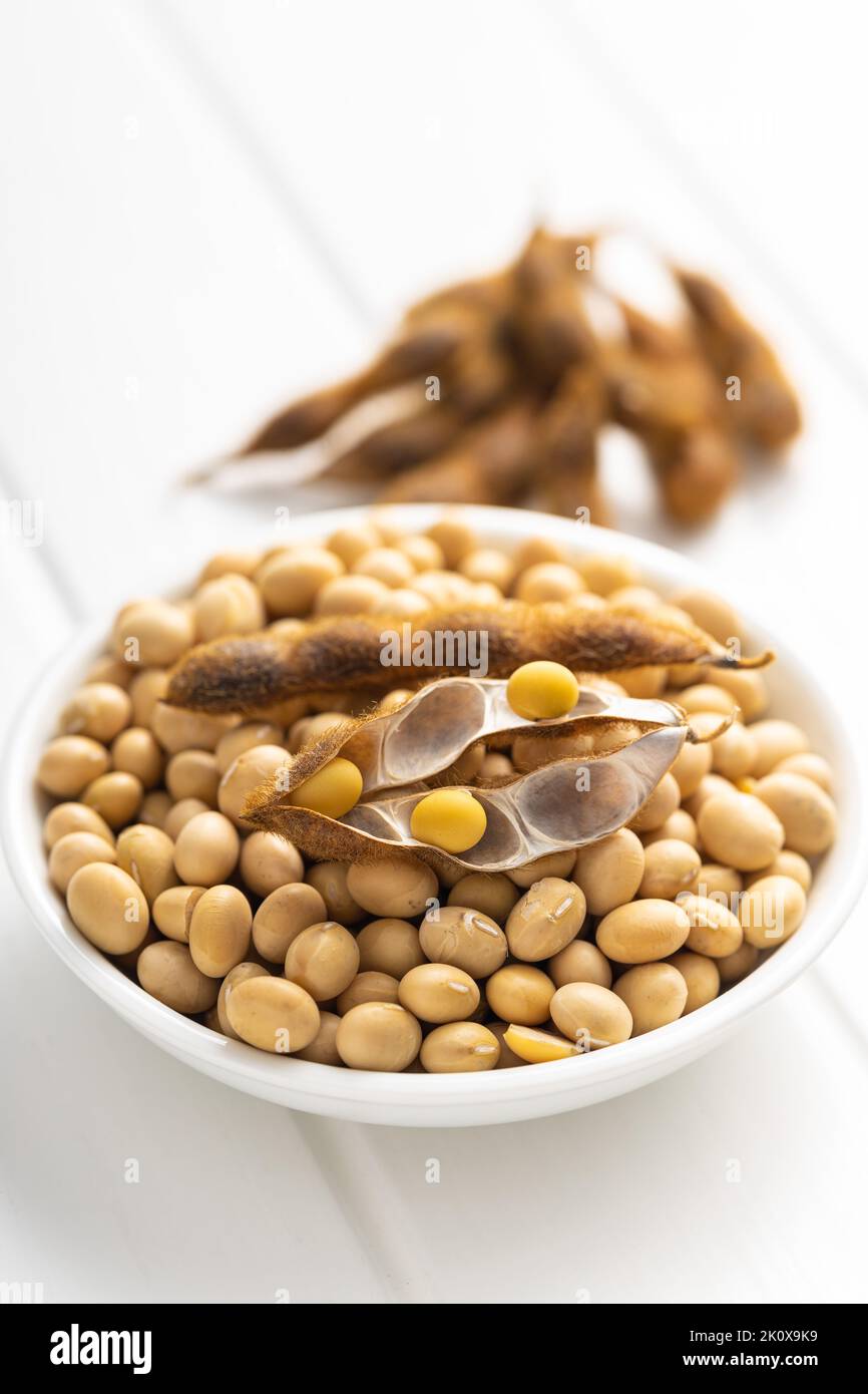 Soy beans. Dried soybean pod in bowl on the white table. Stock Photo