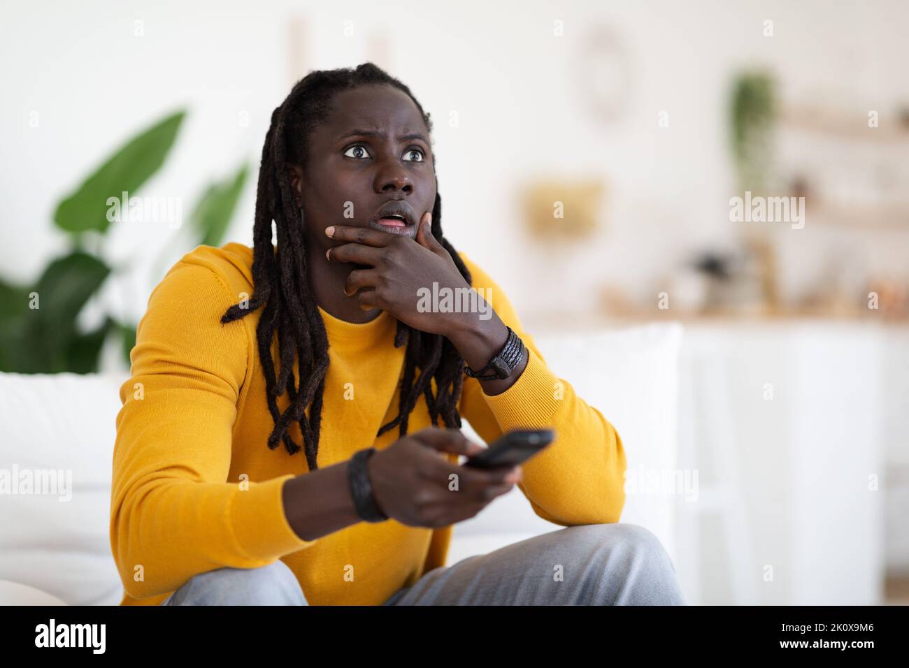 Portrait Of Shocked Black Man With Remote Controller In Hand At Home Stock Photo