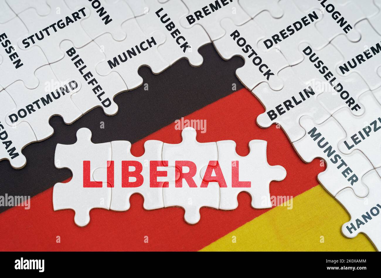 National concept. On the flag of Germany there are puzzles with the names of cities and puzzles with the inscription - Liberal Stock Photo