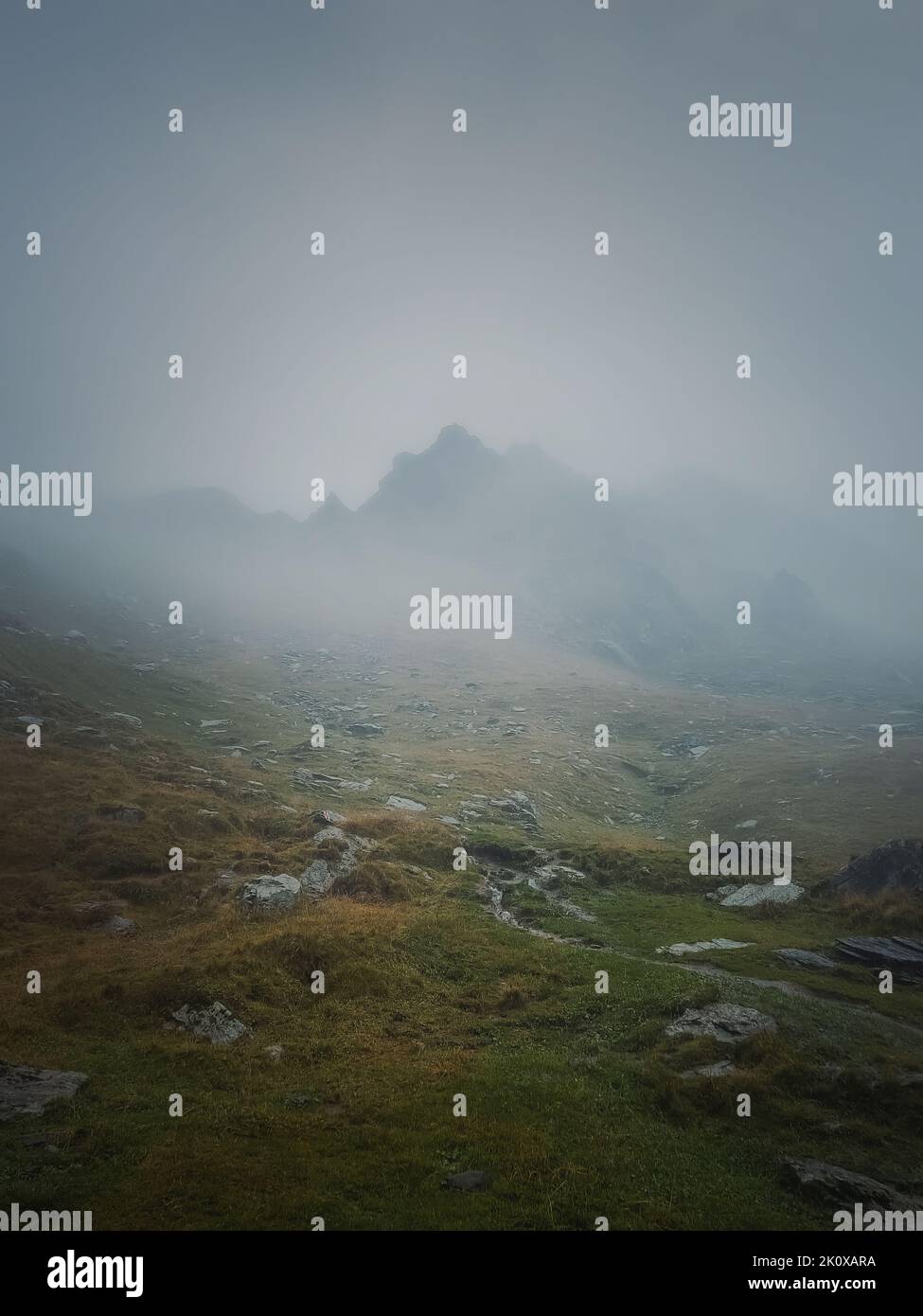 Transfagarasan mountain peak seen through the dense fog. Rainy scene in the mounts, hiking in the mist Stock Photo