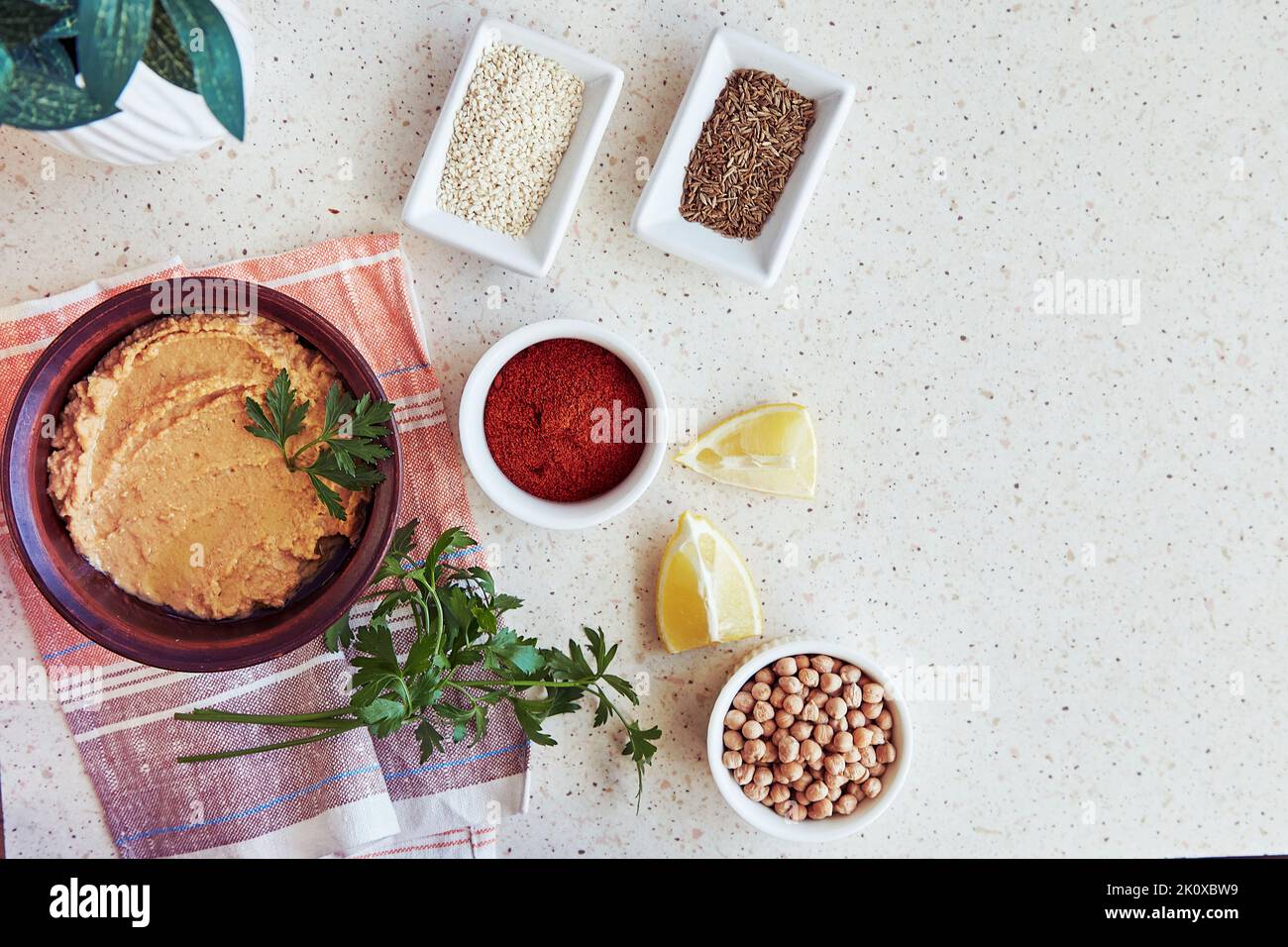 Hummus with chickpeas and tahini sauce in the bowl parsley, lemon