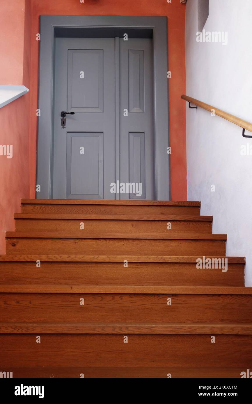 stairs leading to a closed grey door Stock Photo