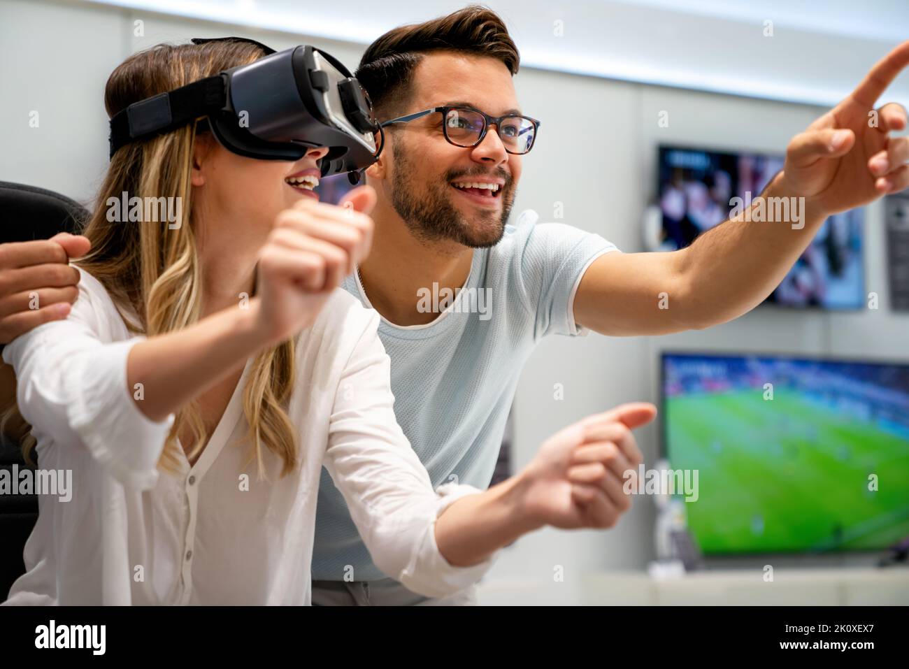 Couple enjoying with VR goggles at tech store. Shopping virtual reality