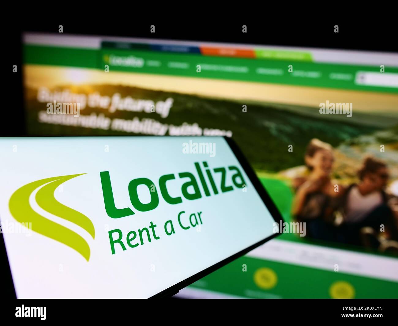 Cellphone with logo of Brazilian company Localiza Rent a Car S.A. on screen in front of business website. Focus on left of phone display. Stock Photo