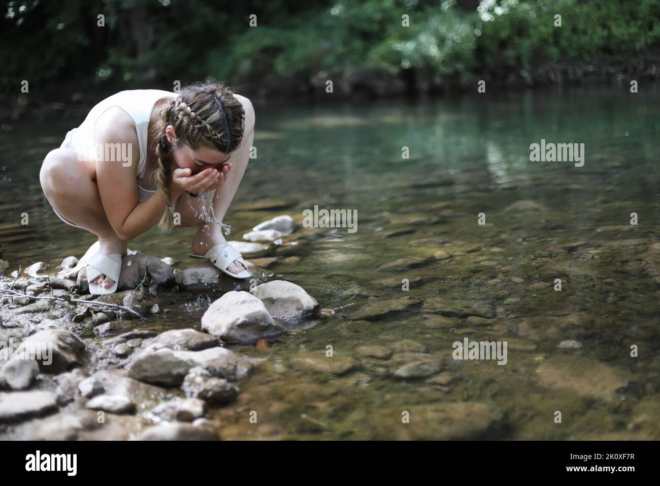 Woman washing face in lake hi-res stock photography and images - Alamy