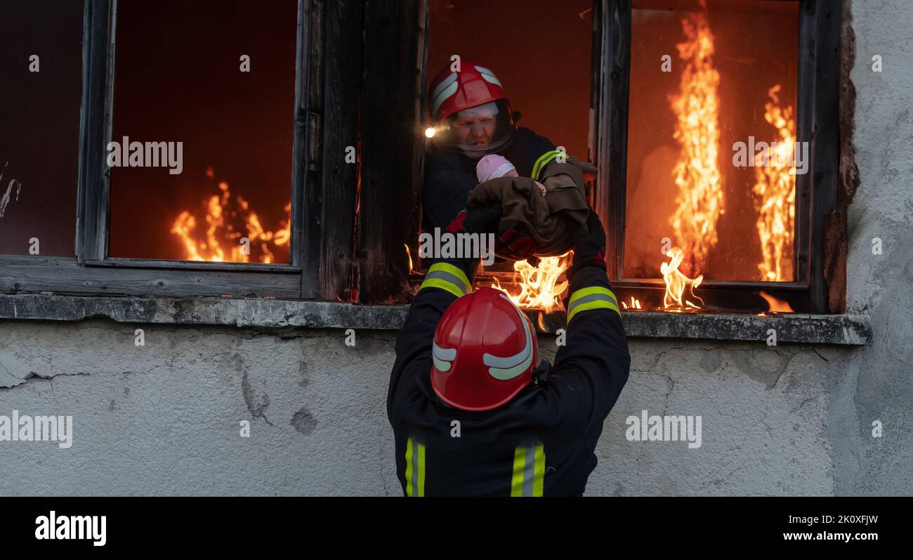 Firefighter hero carrying baby girl out from burning building area from ...
