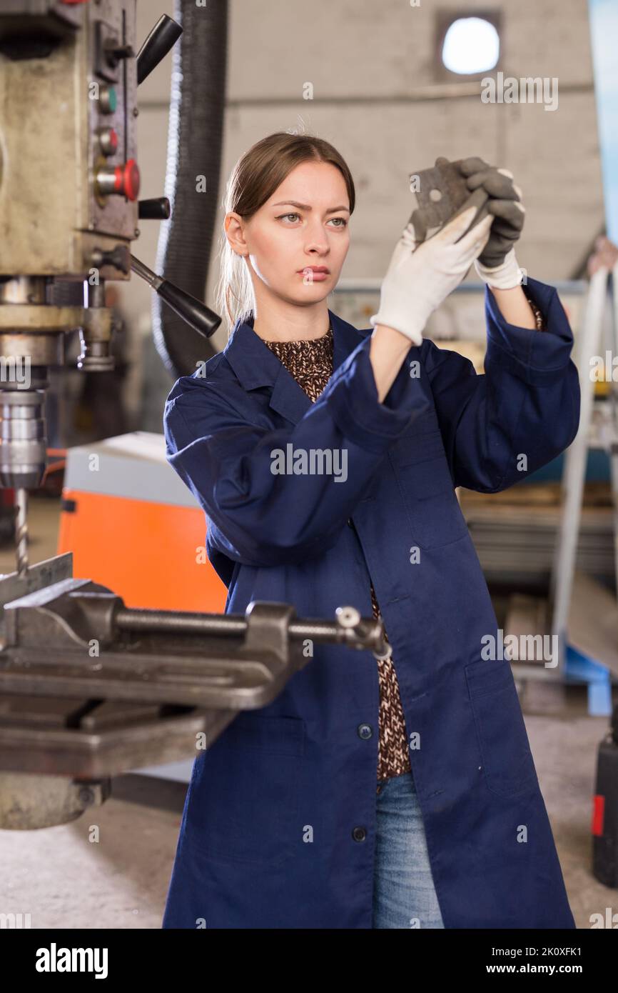 Confident woman mechanic using drilling machine in workshop Stock Photo