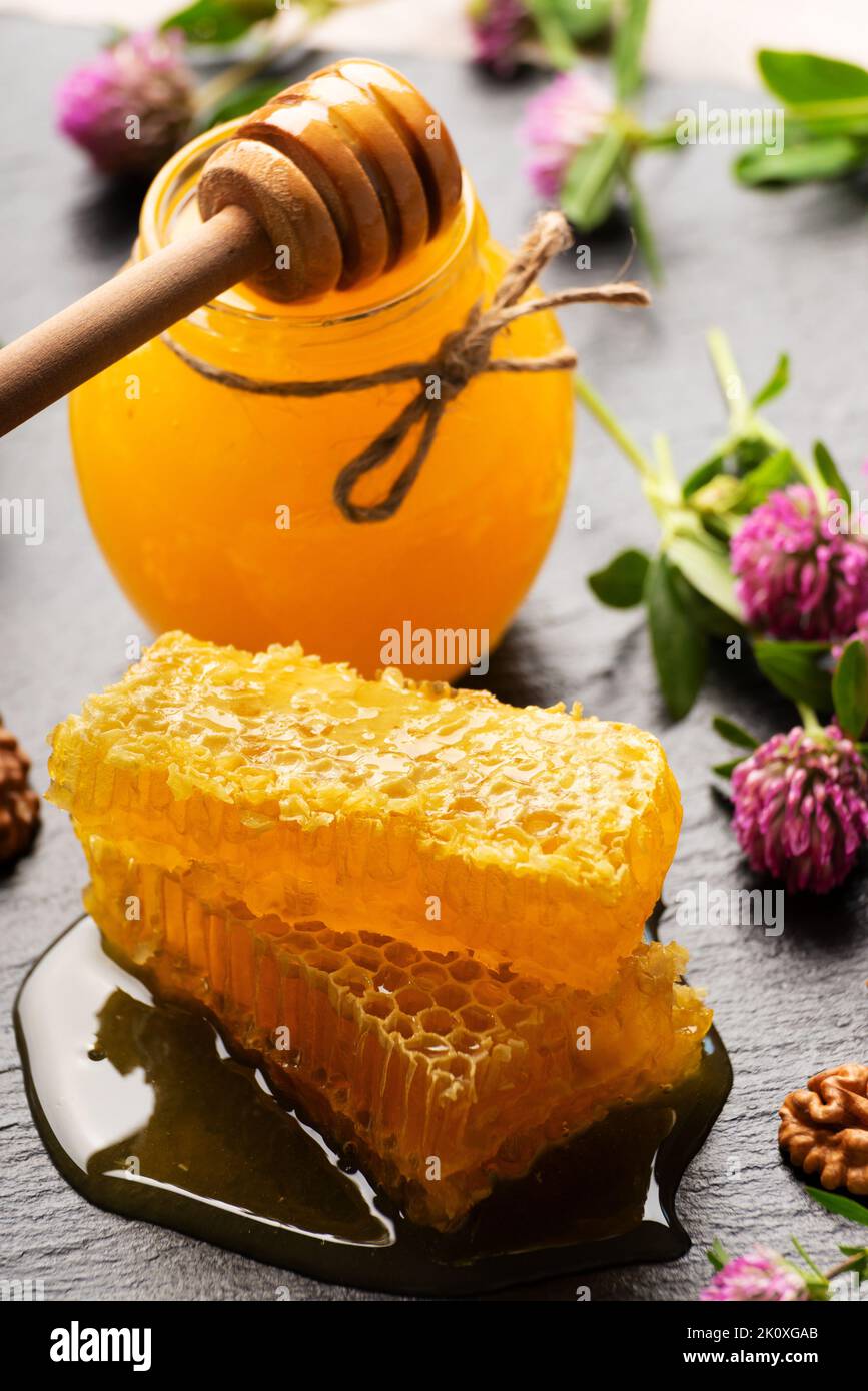 Honeycomb on slate tray with honey and nuts on kitchen table Stock Photo
