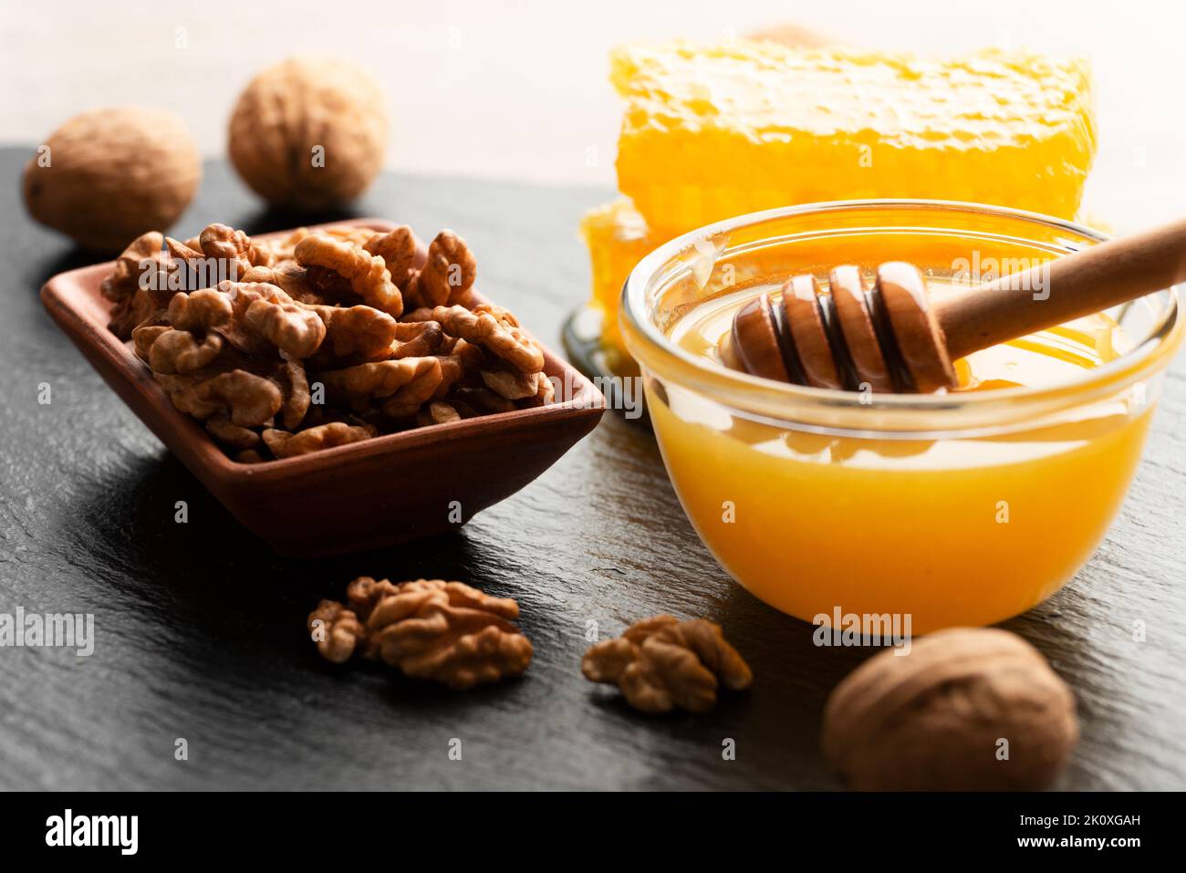Slate tray with honey walnuts and honeycomb on kitchen table Stock Photo