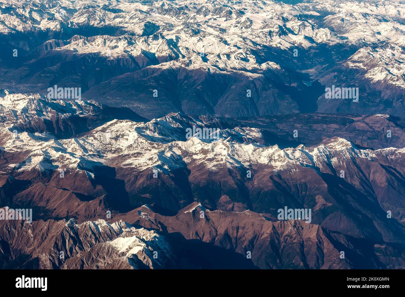 Aerial view of Alps with summits covered with snow as seen from airplane. Stock Photo