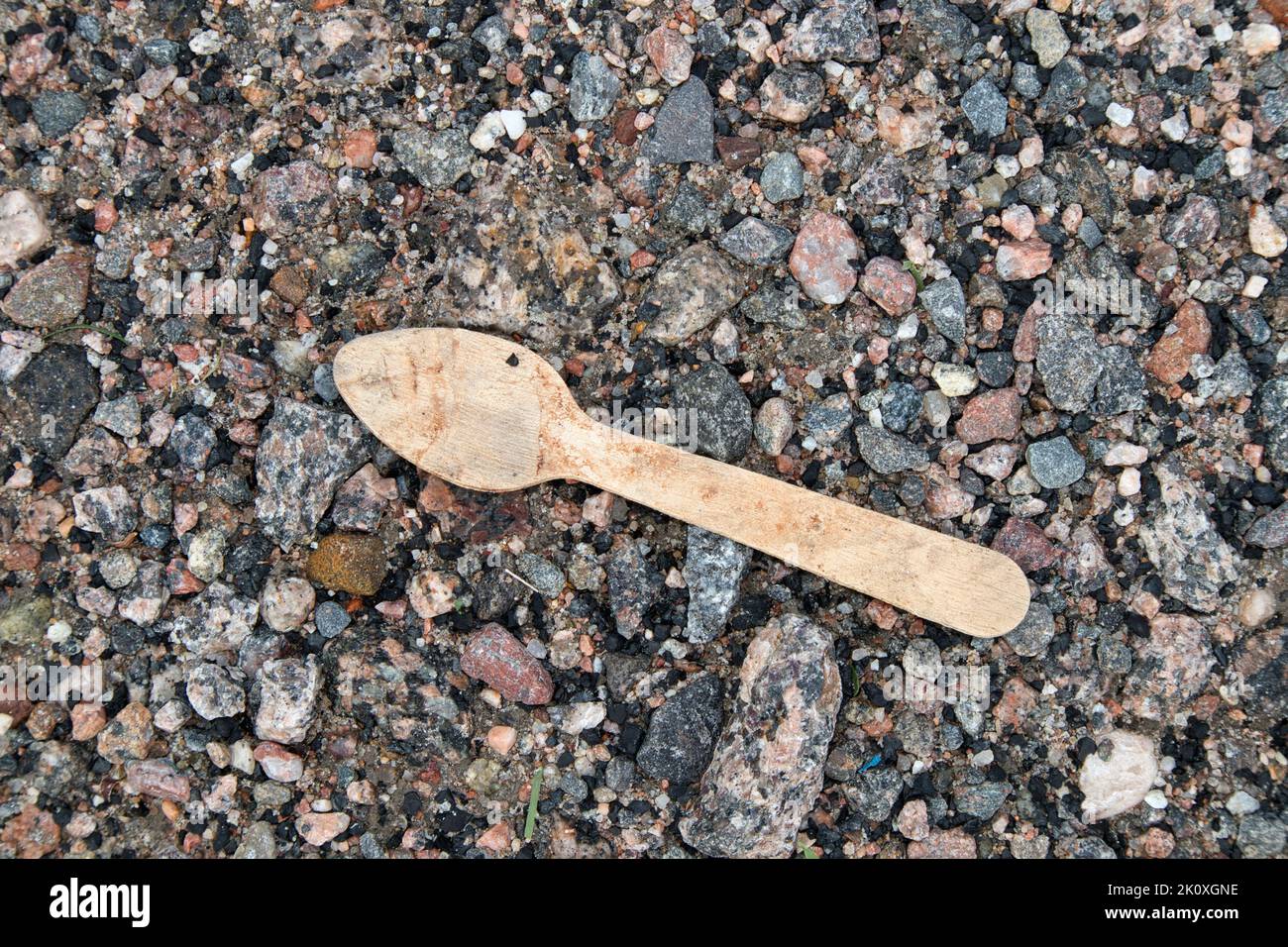 Biodegradable wooden spoon on the ground outdoors Stock Photo