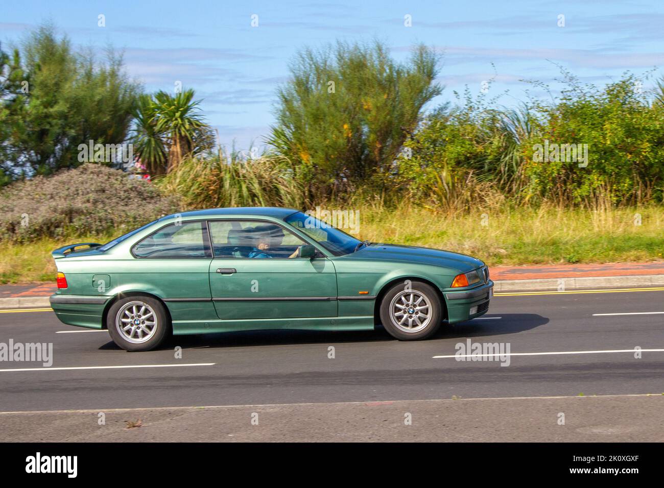 1999 90s nineties Green BMW 3-Series Coupe 318i S 2d (1.9) travelling on the seafront promenade in Southport, UK Stock Photo