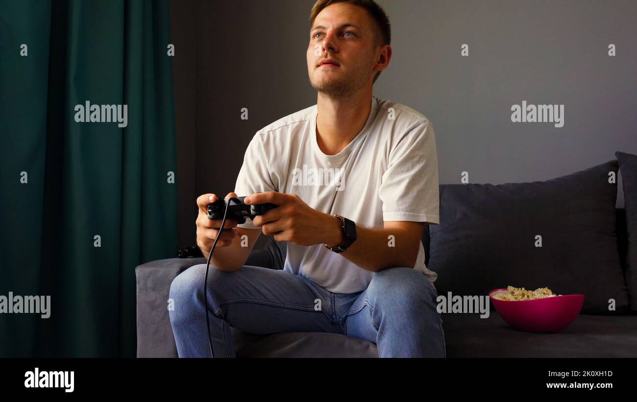 Excited young handsome man playing video game  Stock Photo