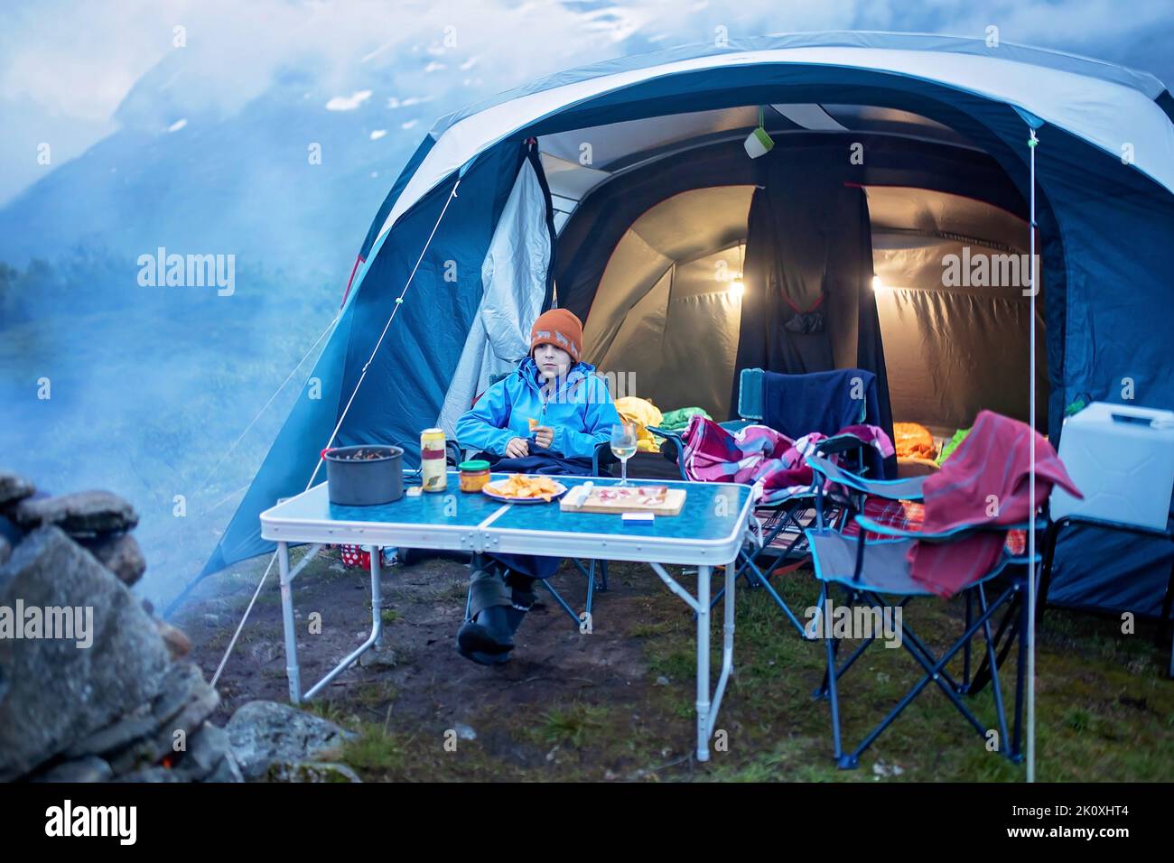 Kids, sitting around campfire at night, enjoying wild camping, family