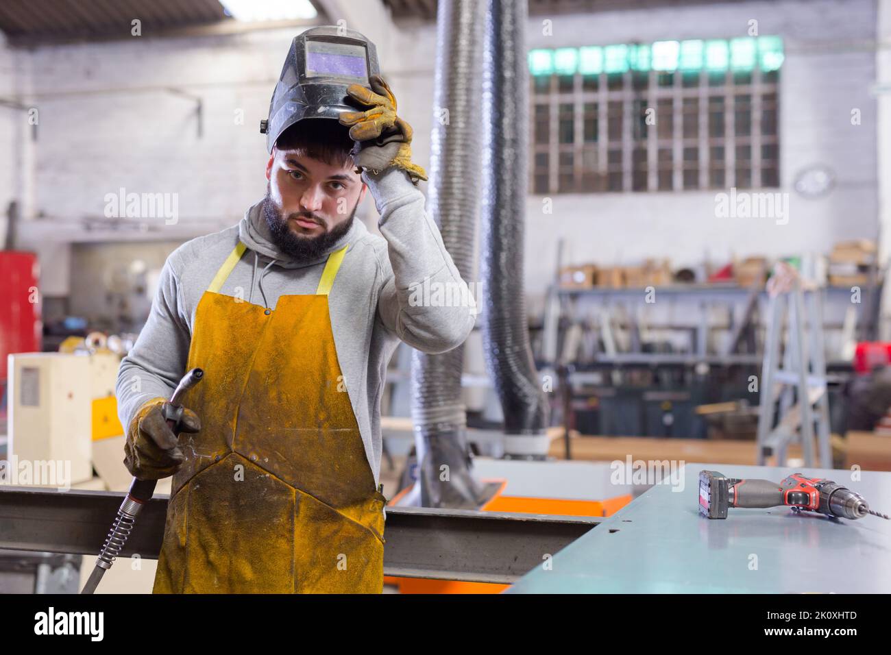 Man using welder for construction work at the workshop Stock Photo