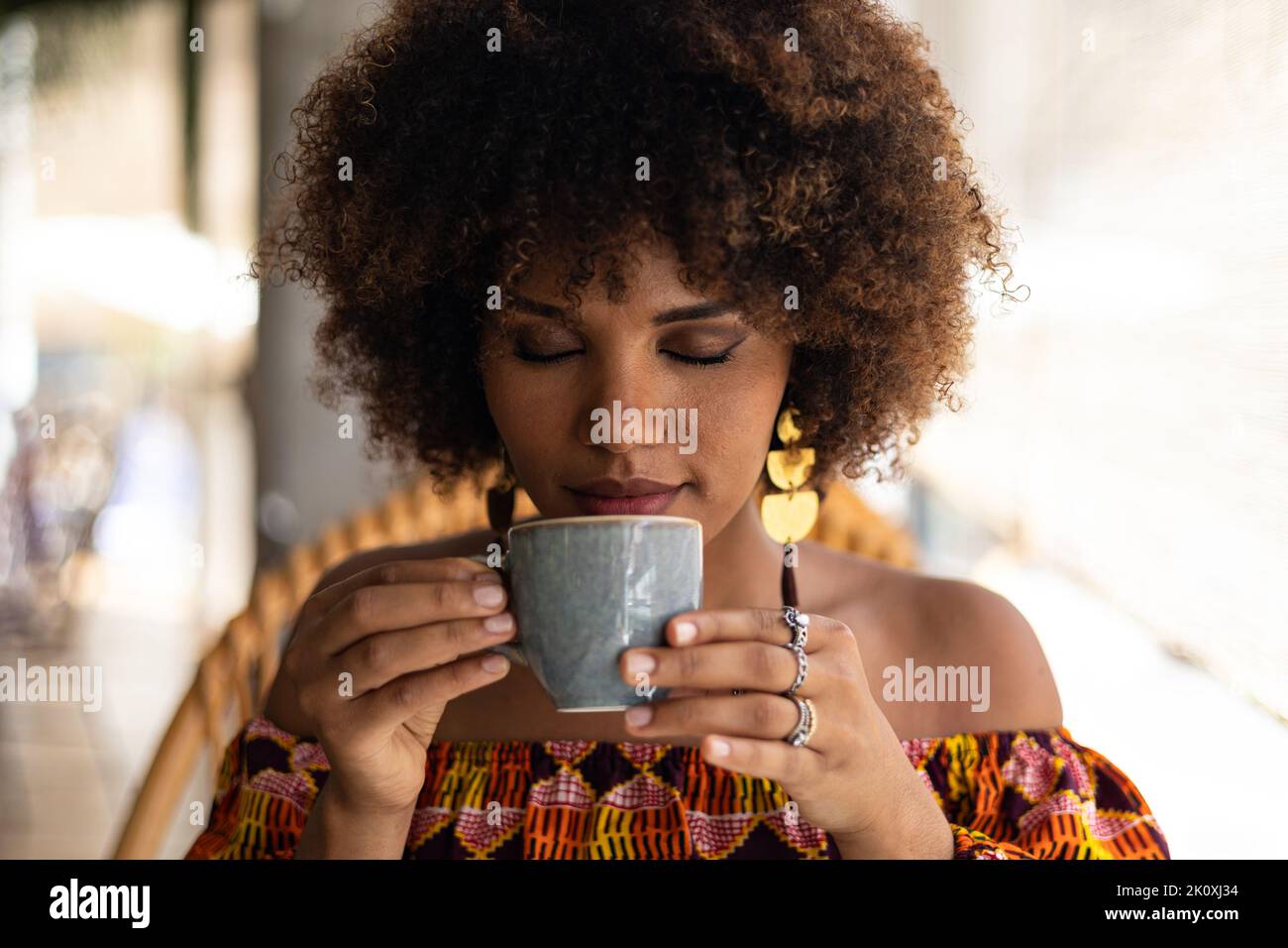 Young African woman smelling coffee cup Stock Photo - Alamy